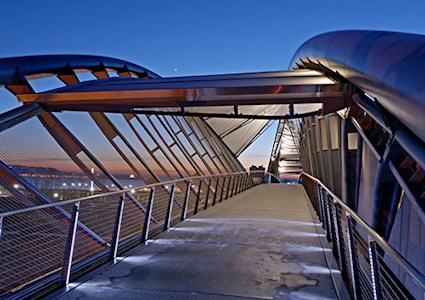Illuminated footbridge over Seattle cityscape at night