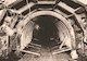 Sepia-toned photograph shows a tunnel being built with its timber supports. 