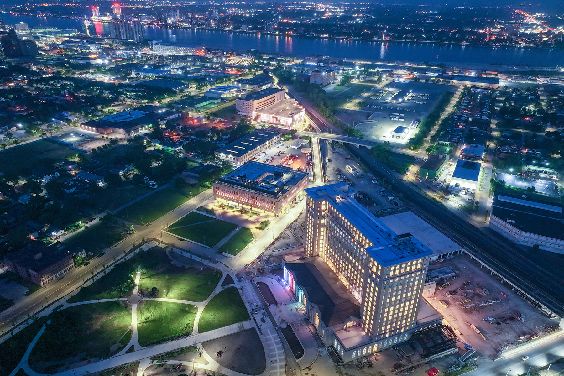 The towering former train station is shown at night, all lit up.