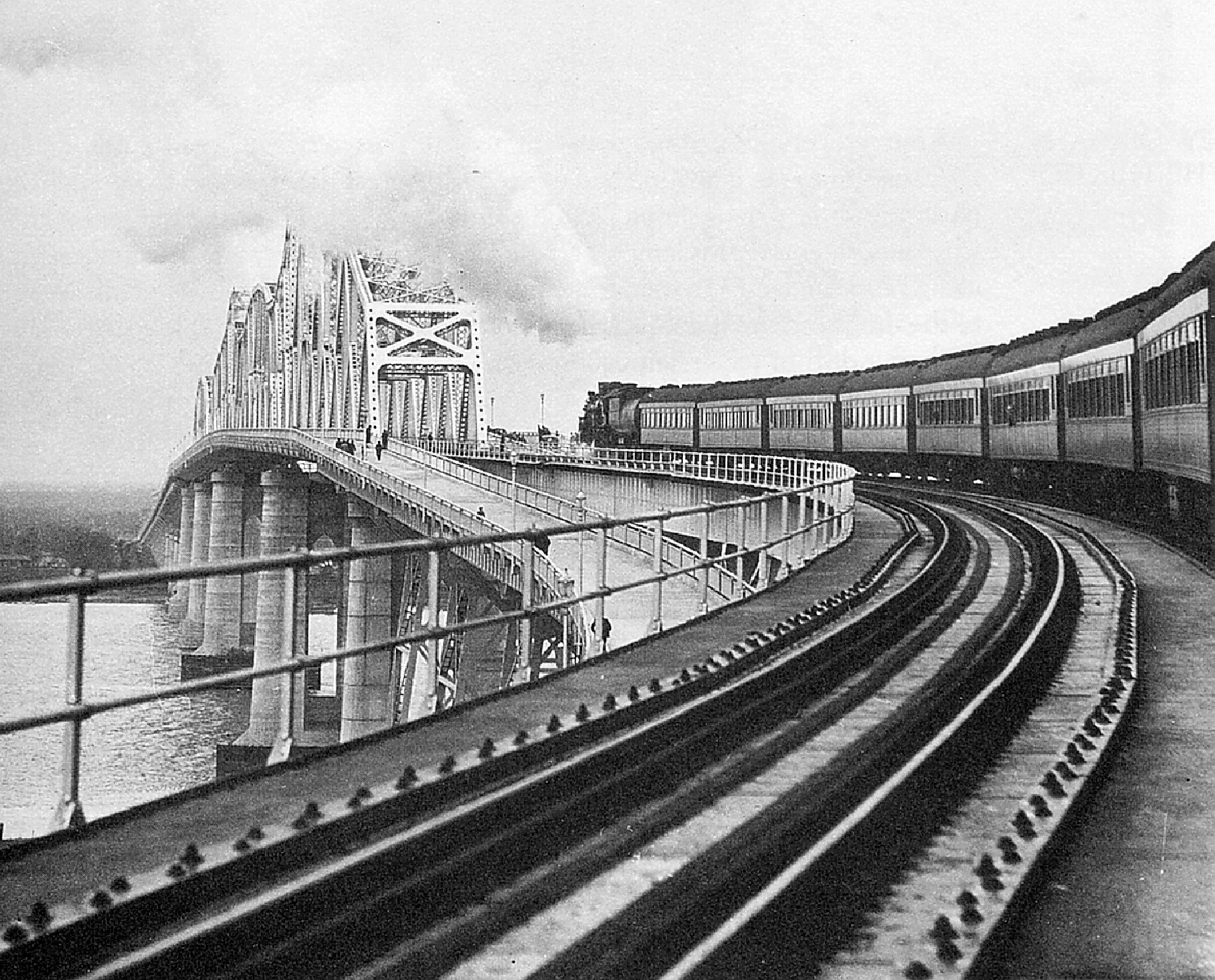 Photo shows a train making its way across a bridge. 