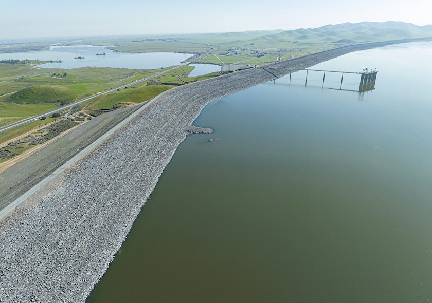 Image shows a dam with two large bodies of water separated by rocks and land.